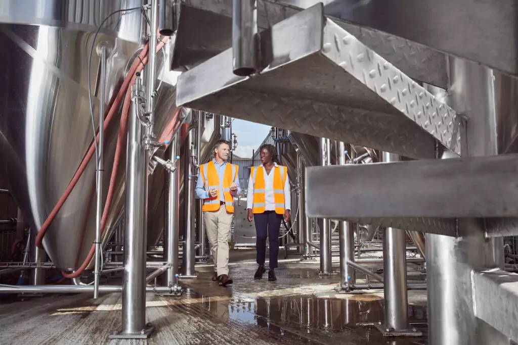 A man and woman walking through a manufacturing facility.