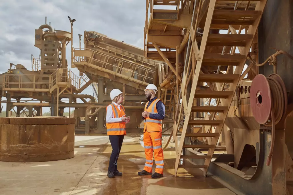 A woman and man speaking on a construction site.