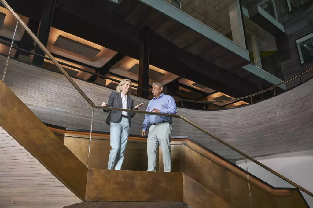 A man and a woman speaking on a staircase.