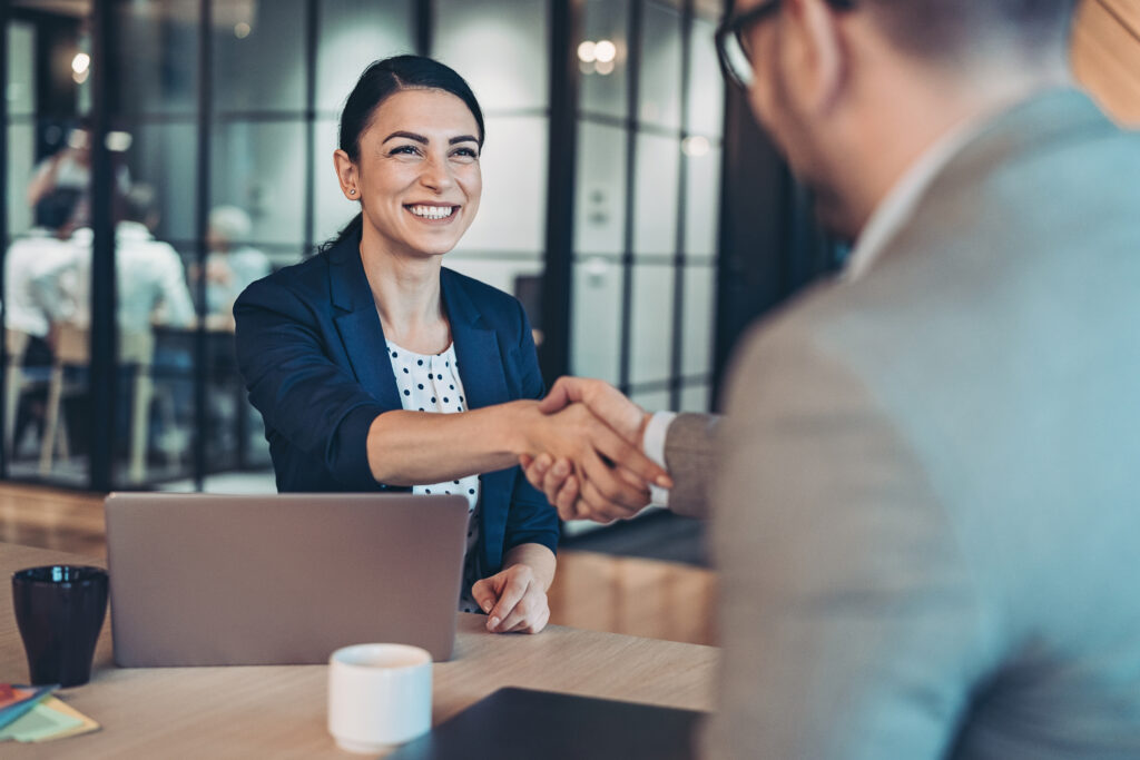 A woman and a man shaking hands.