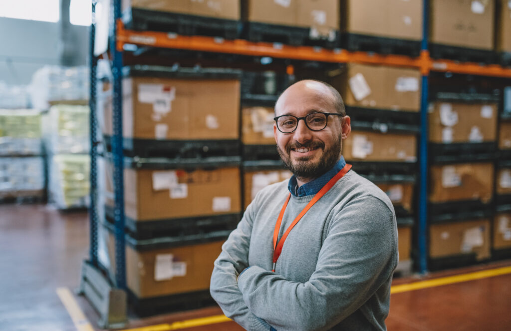 A man standing in front of boxes in a warehouse