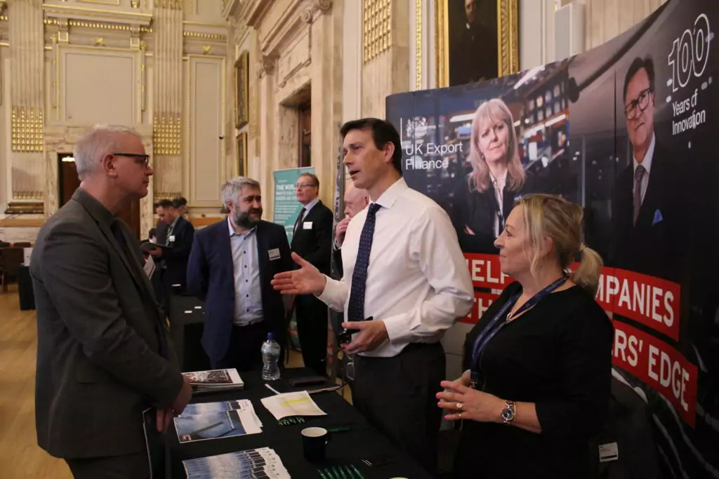 two UKEF representatives talk with a delegate at a Supplier Fair