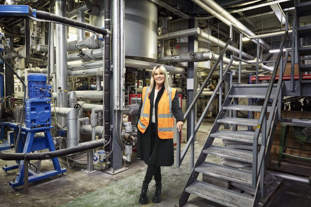 A woman in high vis stands in a factory