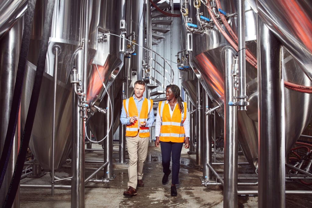 A man and woman walking through a machinery room.