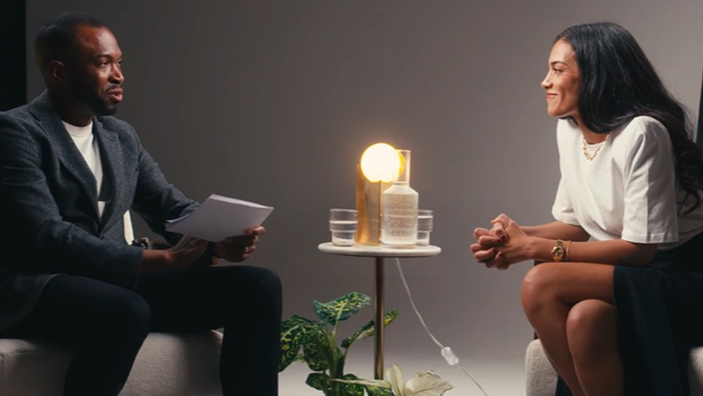 A man and a woman having an interview around a table.